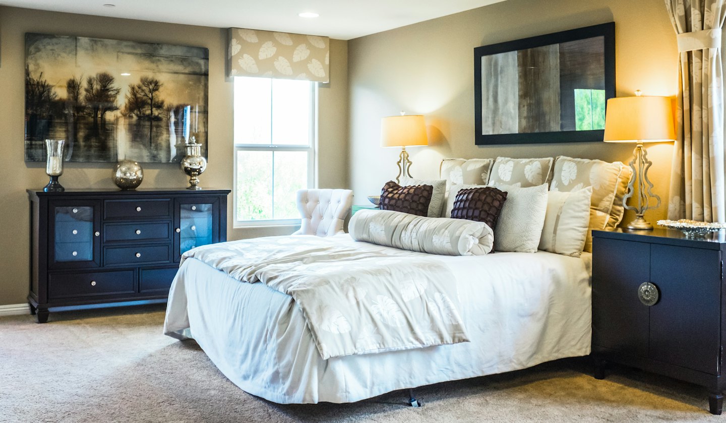 Un dormitorio de lujo con una cama grande y lámparas ornamentadas.
